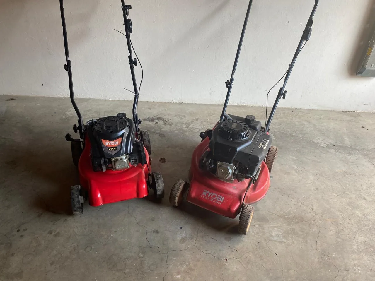 Two serviced lawnmowers ready for collection